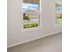 Bright carpeted bedroom showcasing street view from two windows at 11720 Renaissance Blvd, Venice, FL 34293