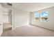 Bright bedroom featuring soft carpet, two windows with a lake view, and an adjacent closet at 11720 Renaissance Blvd, Venice, FL 34293