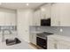 Well-equipped kitchen featuring stainless steel appliances, white cabinets, and stylish backsplash at 11720 Renaissance Blvd, Venice, FL 34293