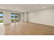 Spacious living room with wood-look tile floors and sliding glass doors to a lake view at 11720 Renaissance Blvd, Venice, FL 34293