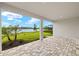 Covered patio with brick flooring overlooking a green lawn and calm lake views at 11720 Renaissance Blvd, Venice, FL 34293