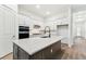 Modern kitchen with a large center island, white cabinets, stainless steel appliances, and hardwood floors at 1650 Fallon Pass, Zephyrhills, FL 33541