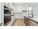 Contemporary kitchen featuring stainless steel appliances, white cabinets, and a marble-topped island at 1650 Fallon Pass, Zephyrhills, FL 33541