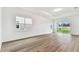 Bright, spacious living room with hardwood floors and large windows offering a view of the backyard at 1650 Fallon Pass, Zephyrhills, FL 33541