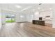 Open-concept living area flowing into a modern kitchen with ample natural light and hardwood floors at 1650 Fallon Pass, Zephyrhills, FL 33541