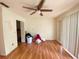 Bedroom with wood floors, fan and sliding doors to exterior at 3712 Murray Dale Dr, Valrico, FL 33596