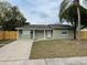 Newly renovated light green house with a wooden fence at 1024 Jadewood Ave, Clearwater, FL 33759