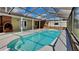Inviting screened-in pool with brick patio and outdoor fireplace at 6969 Oldgate Cir, New Port Richey, FL 34655