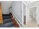 Staircase with a chairlift and access to laundry area at 6435 Thicket Trl, New Port Richey, FL 34653