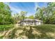 Expansive backyard of modern home surrounded by lush greenery at 22426 Golden Retriever Ln, Brooksville, FL 34601