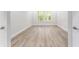 Bright bedroom featuring new light wood flooring, white walls, and abundant natural light from the windows at 22426 Golden Retriever Ln, Brooksville, FL 34601