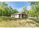 A single-story home with a grey exterior and a well-manicured front lawn and landscaping at 22426 Golden Retriever Ln, Brooksville, FL 34601