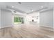 Spacious living room with light wood floors and sliding glass doors opening to the outdoors at 22426 Golden Retriever Ln, Brooksville, FL 34601