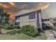 Exterior view of condo building at sunset, featuring landscaping and parking at 428 Windrush Bay Dr, Tarpon Springs, FL 34689