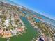 High-angle aerial view featuring a waterfront community with canals, homes, and a bridge in the distance at 2832 W Vina Del Mar Blvd, St Pete Beach, FL 33706
