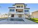 Back of modern home with balconies, a pool, and a staircase leading to the upper level at 2832 W Vina Del Mar Blvd, St Pete Beach, FL 33706