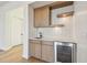 Elegant bar area with sink, beverage cooler, and custom cabinetry providing ample storage at 2832 W Vina Del Mar Blvd, St Pete Beach, FL 33706