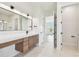 Bright bathroom featuring a long vanity with double sinks and a view to the adjoining room at 2832 W Vina Del Mar Blvd, St Pete Beach, FL 33706