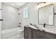 Modern bathroom features a tub with stylish marble wall, vanity with sleek black hardware and ample natural light at 2832 W Vina Del Mar Blvd, St Pete Beach, FL 33706