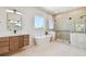 A luxurious bathroom with a soaking tub, glass enclosed shower and floating vanity at 2832 W Vina Del Mar Blvd, St Pete Beach, FL 33706