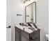 Modern bathroom with marble countertop, dark wooden vanity, stylish mirror, and sleek black hardware offering contemporary appeal at 2832 W Vina Del Mar Blvd, St Pete Beach, FL 33706