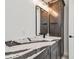 Well-lit vanity with marble countertops, dark wood cabinets, and a sleek, framed mirror enhancing the bathroom's elegance at 2832 W Vina Del Mar Blvd, St Pete Beach, FL 33706