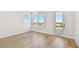 Bright bedroom with light wood floors and multiple windows showcasing neighborhood water views at 2832 W Vina Del Mar Blvd, St Pete Beach, FL 33706