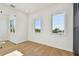 Bright, minimalist bedroom featuring hardwood floors and ample natural light at 2832 W Vina Del Mar Blvd, St Pete Beach, FL 33706