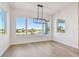 Bright dining room with hardwood floors, modern chandelier, and large windows offering water views at 2832 W Vina Del Mar Blvd, St Pete Beach, FL 33706