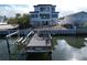 New waterfront home with boat lift and dock featuring seating offers tranquil spot to enjoy the serene water views at 2832 W Vina Del Mar Blvd, St Pete Beach, FL 33706