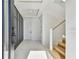 Bright foyer with wood floors, a black accent wall, and a staircase with metal railing at 2832 W Vina Del Mar Blvd, St Pete Beach, FL 33706