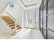 Sunlit foyer featuring wood staircase and a stylish black accent wall at 2832 W Vina Del Mar Blvd, St Pete Beach, FL 33706