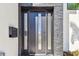 Modern front door featuring sidelights and a stacked stone accent wall at 2832 W Vina Del Mar Blvd, St Pete Beach, FL 33706
