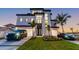 Luxury home with a two-car garage, modern design, and a well-kept lawn with high-end vehicles parked at 2832 W Vina Del Mar Blvd, St Pete Beach, FL 33706