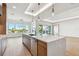 Bright, modern kitchen with a large island, stainless steel appliances, and hardwood floors with waterfront views at 2832 W Vina Del Mar Blvd, St Pete Beach, FL 33706
