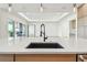 Close up of a modern kitchen sink, countertop, and view of the living area at 2832 W Vina Del Mar Blvd, St Pete Beach, FL 33706
