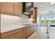 Modern kitchen features sleek cabinetry, stainless steel appliances, backsplash and a cooktop on the counter at 2832 W Vina Del Mar Blvd, St Pete Beach, FL 33706