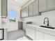 Well-lit laundry room featuring shaker cabinets, quartz countertops, a sink, and modern fixtures at 2832 W Vina Del Mar Blvd, St Pete Beach, FL 33706