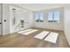 Bright living room with wood floors, modern light fixture, and large windows at 2832 W Vina Del Mar Blvd, St Pete Beach, FL 33706