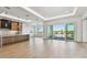 Open-concept living space showcasing a modern kitchen with a view of the waterfront balcony at 2832 W Vina Del Mar Blvd, St Pete Beach, FL 33706