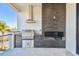 Covered patio with an outdoor kitchen, stainless grill, and stone backsplash at 2832 W Vina Del Mar Blvd, St Pete Beach, FL 33706