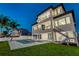 A modern home back view with pool, balconies, and a lush green lawn at 2832 W Vina Del Mar Blvd, St Pete Beach, FL 33706