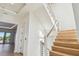 Bright interior staircase featuring wood steps and minimalist metal railing at 2832 W Vina Del Mar Blvd, St Pete Beach, FL 33706