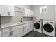 Laundry room with white cabinets, hexagon tile floor, and a sink at 3907 W Mckay Ave, Tampa, FL 33609