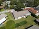 Aerial view of the property with a well-maintained lawn and mature trees at 12210 Buttonwood Row, Hudson, FL 34667