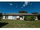 Spacious backyard with manicured lawn, trimmed hedges, and exterior of the house at 12210 Buttonwood Row, Hudson, FL 34667