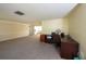 Inviting living room featuring plush carpeting, a large window, and adjacent sunroom at 12210 Buttonwood Row, Hudson, FL 34667