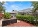 Secluded backyard area featuring lush greenery and decorative outdoor furniture at 30735 Lanesborough Cir, Wesley Chapel, FL 33543