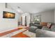 Bright living room with hardwood floors, gray sectional sofa, and large TV at 30735 Lanesborough Cir, Wesley Chapel, FL 33543