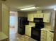 Kitchen with black appliances and light wood cabinets at 34303 Lodge Dr, Wesley Chapel, FL 33543